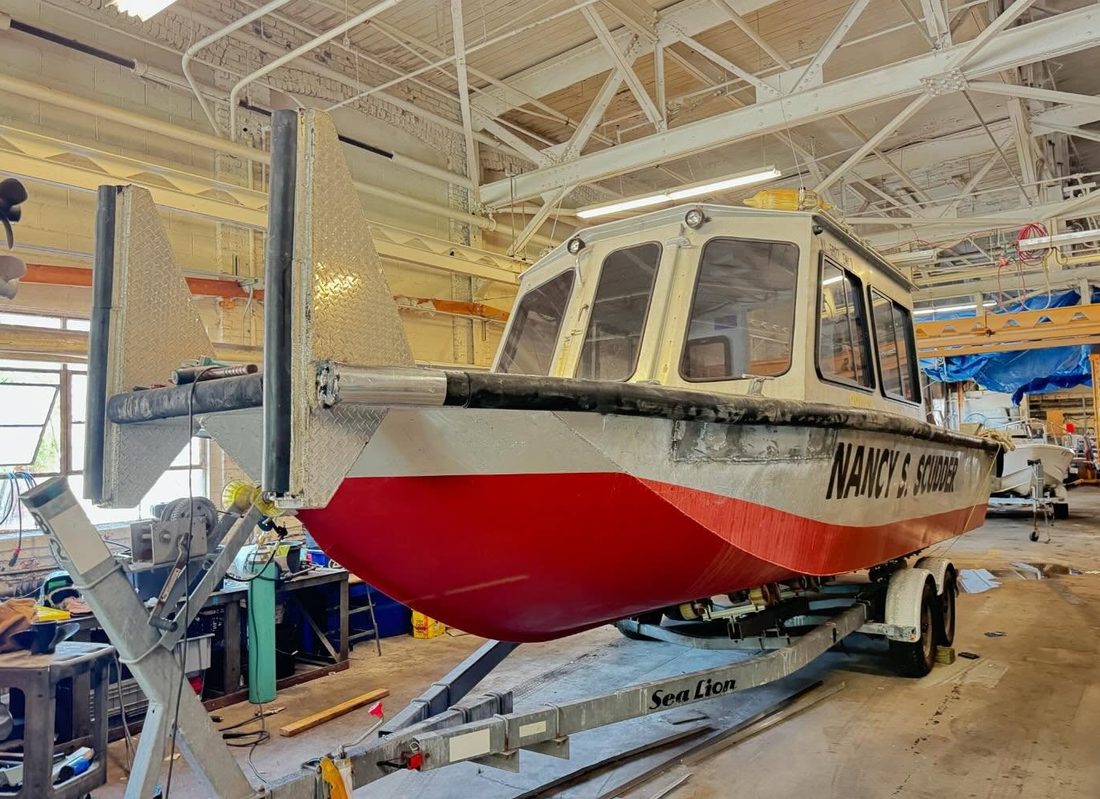 Boat on a trailer inside the Ace Marine shop